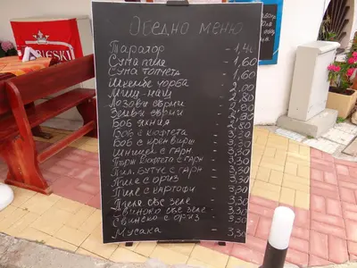 a chalkboard sign with a menu on a sidewalk at Guest House Rosa in Kiten