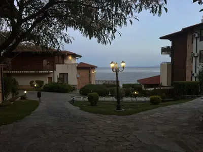 a street light in front of a building with the ocean at Garden of Eden - Studio in Sveti Vlas
