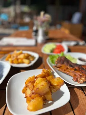 a wooden table with plates of food on it at Garden of Eden - Studio in Sveti Vlas