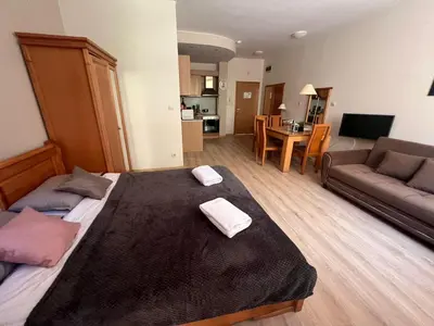 a bedroom with a large bed with two towels on it at Garden of Eden - Studio in Sveti Vlas