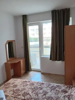 a bedroom with a bed and a mirror and a window at Aparthotel Rutland bay in Ravda
