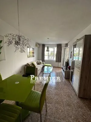 a living room with a green table and a couch at Aparthotel Rutland bay in Ravda