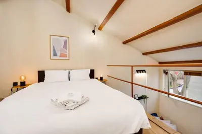 a large white bed in a room with a window at Cozy Nest Charming Loft in the heart of Varna in Varna City