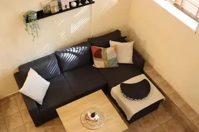 a black leather couch with pillows and a table at Cozy Nest Charming Loft in the heart of Varna in Varna City