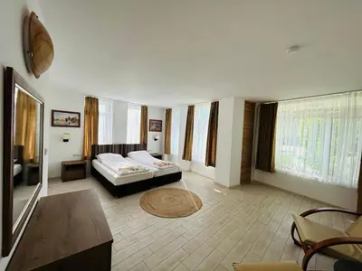a hotel room with a bed and a living room at Apolonia Apartments - Boutique Family Residence in Sozopol