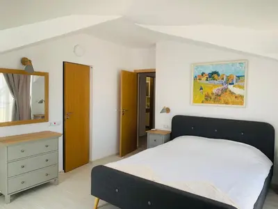a bedroom with a bed and a dresser and a mirror at Apolonia Apartments - Boutique Family Residence in Sozopol