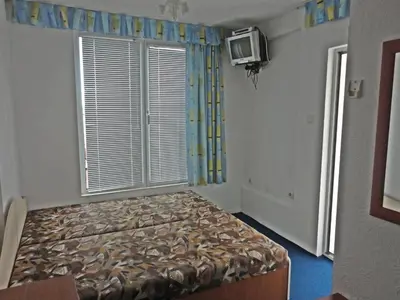 a bedroom with a bed and a tv and a window at Guest Rooms Casa Luba in Sveti Vlas