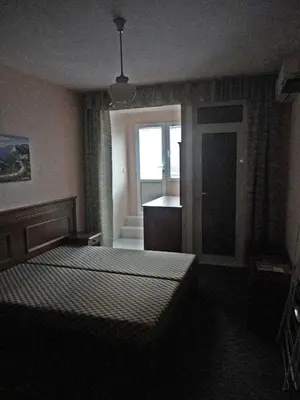 a bedroom with two beds and a kitchen with a window at Guest Rooms Casa Luba in Sveti Vlas