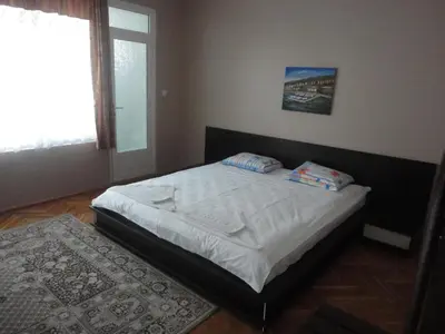a small bedroom with a bed with white sheets and a window at Guest Rooms Casa Luba in Sveti Vlas