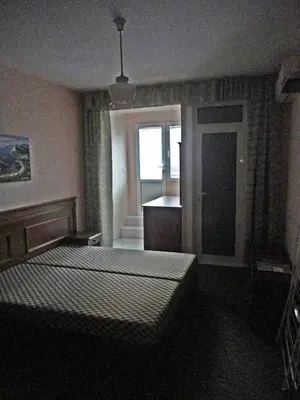 a bedroom with two beds and a kitchen with a window at Guest Rooms Casa Luba in Sveti Vlas