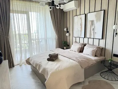 a bedroom with a large bed with a suitcase on it at Kristin`s Home in Burgas City