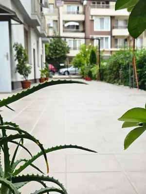 an umbrella in the middle of a courtyard at Guest House Petrovi in Ravda