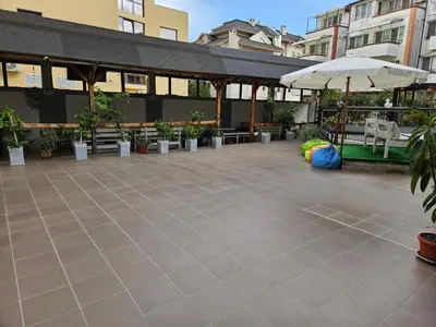 an empty courtyard with plants and an umbrella at Guest House Petrovi in Ravda