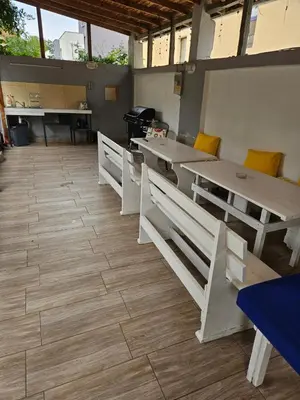 a room with tables and benches and a grill at Guest House Petrovi in Ravda