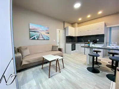a living room with a couch and a kitchen at NJ Luxury rooms and suites in Varna City