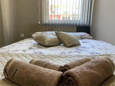 a bed with two pillows on it in a bedroom at NJ Luxury rooms and suites in Varna City