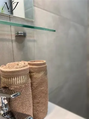 a bathroom with two towels on a sink at NJ Luxury rooms and suites in Varna City