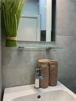 a bathroom sink with a faucet and a mirror at NJ Luxury rooms and suites in Varna City