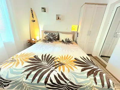 a bedroom with a bed with a tropical print on it at Studio Aloha in Burgas City