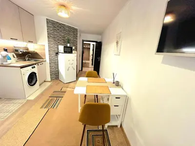 a kitchen with a table and chairs in a room at Studio Aloha in Burgas City