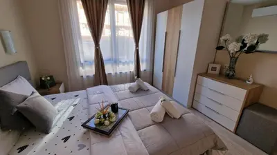 a large bed with a tray of flowers on it at Sea Dreams Sunrise Apartment in Sveti Vlas