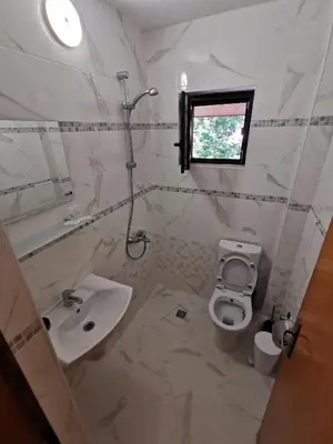 a bathroom with a sink and a toilet and a window at Guest House Liliya in Sozopol