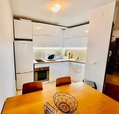 a small kitchen with a wooden table and chairs at Two-bed flat in Sunny Beach with pool view in Sunny Beach