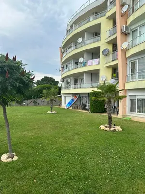 a large building with palm trees in a yard at Alex Beach in Elenite