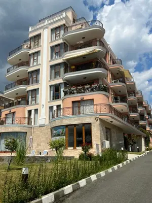 a large apartment building with balconies on a street at Phoenix APARTMENT Апартамент Феникс in Sveti Vlas