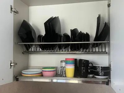 a kitchen pantry with plates and cups on a shelf at Phoenix APARTMENT Апартамент Феникс in Sveti Vlas