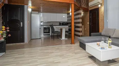 a living room with a couch and a kitchen at Paradise Sarafovo Beach in Burgas City