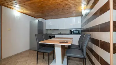 a small kitchen with a wooden table and chairs at Paradise Sarafovo Beach in Burgas City