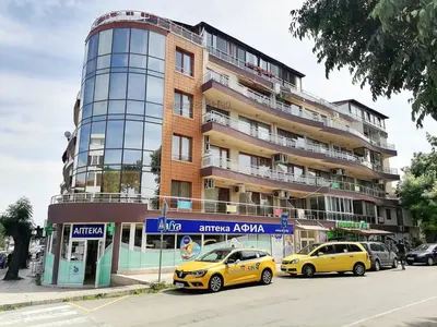 two yellow taxis parked in front of a building at Paradise Sarafovo Beach in Burgas City