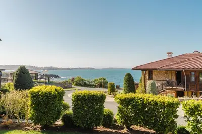 a house with hedges in front of the water at Созопол Sozopol- SOZOPOLIS - MORE SUN 2В in Sozopol