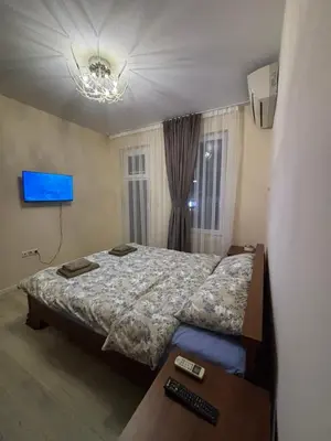 a bedroom with a bed and a television and a desk at GRAND APARTMENT BOGORIDI - top center near to sea and sea garden in Burgas City