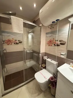 a bathroom with a shower and a toilet and a sink at GRAND APARTMENT BOGORIDI - top center near to sea and sea garden in Burgas City