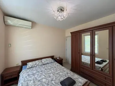a bedroom with a bed and a chandelier at GRAND APARTMENT BOGORIDI - top center near to sea and sea garden in Burgas City