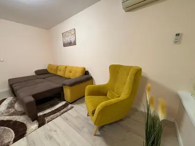 a living room with a couch and a chair at GRAND APARTMENT BOGORIDI - top center near to sea and sea garden in Burgas City