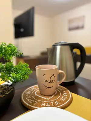a coffee cup with a face drawn on it on a table at GRAND APARTMENT BOGORIDI - top center near to sea and sea garden in Burgas City