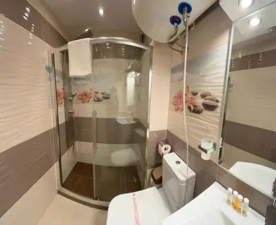 a bathroom with a shower and a toilet and a sink at GRAND APARTMENT BOGORIDI - top center near to sea and sea garden in Burgas City