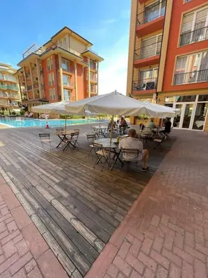 a man sitting at a table under an umbrella at sunny view cacao beach in Sunny Beach