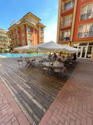 a man sitting at a table under an umbrella at sunny view cacao beach in Sunny Beach