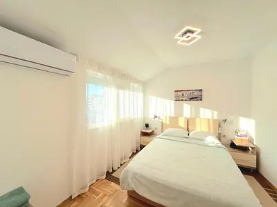 a white bedroom with a bed and a window at Centro apart in Burgas City