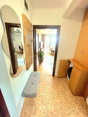 a hallway with a mirror and a chair in a room at Centro apart in Burgas City