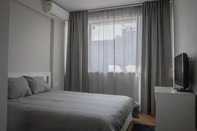 a bedroom with a bed and a tv and a window at Central Apartment in Varna in Varna City