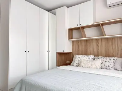 a bedroom with a large bed with white cabinets at Seaside apartment Tyndzha in Pomorie