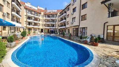 a large blue swimming pool in a courtyard with buildings at Apartment Oasis A4 Kamchia in Bliznatsi
