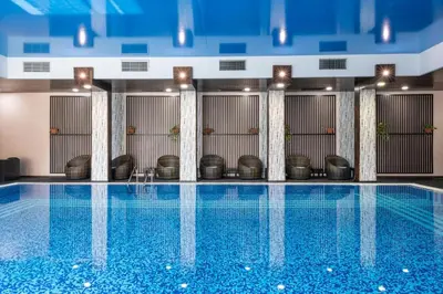 a swimming pool with chairs in a building at Garden of Eden Sea and Pool View in Sveti Vlas