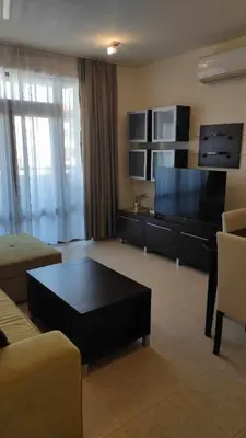 a living room with a large flat screen tv at Garden of Eden Sea and Pool View in Sveti Vlas