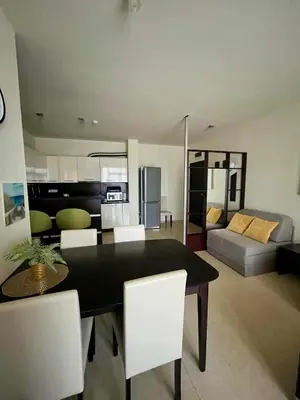 a dining room table with white chairs and a living room at Garden of Eden Sea and Pool View in Sveti Vlas